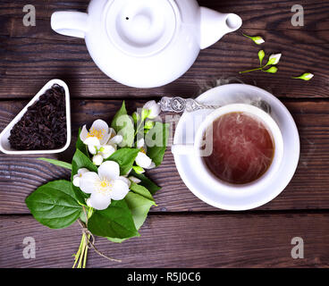 Hot tè nero in una tazza bianca con piattino Foto Stock