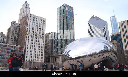 CHICAGO, Illinois, Stati Uniti - Dicembre 12th, 2015: Lo skyline di Chicago attraverso il famoso monumento del Cloud Gate nel Millennium Park con una folla di persone durante il periodo invernale Foto Stock