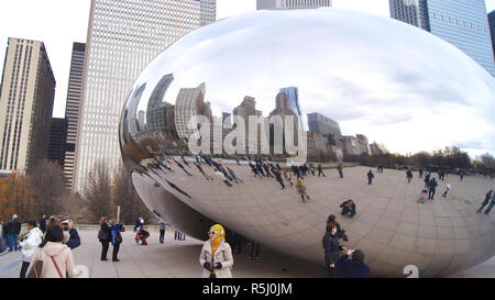 CHICAGO, Illinois, Stati Uniti - Dicembre 12th, 2015: Lo skyline di Chicago attraverso il famoso monumento del Cloud Gate nel Millennium Park con una folla di persone durante il periodo invernale Foto Stock