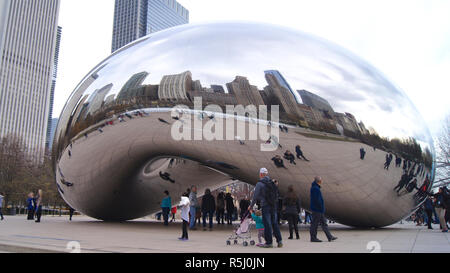 CHICAGO, Illinois, Stati Uniti - Dicembre 12th, 2015: Lo skyline di Chicago attraverso il famoso monumento del Cloud Gate nel Millennium Park con una folla di persone durante il periodo invernale Foto Stock