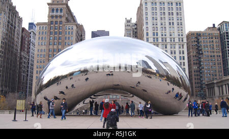 CHICAGO, Illinois, Stati Uniti - Dicembre 12th, 2015: Lo skyline di Chicago attraverso il famoso monumento del Cloud Gate nel Millennium Park con una folla di persone durante il periodo invernale Foto Stock