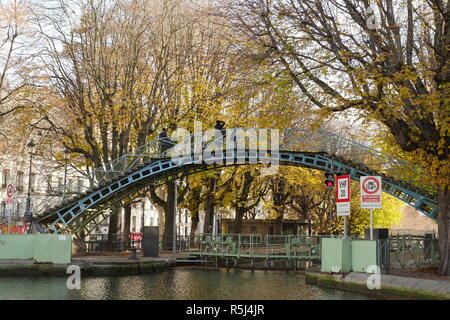 Turisti attraversando un ponte sul Canal Saint Martin a Parigi. Foto Stock
