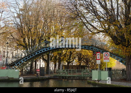 Turisti attraversando un ponte sul Canal Saint Martin a Parigi. Foto Stock
