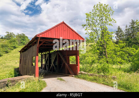 Costruito nel 1887, il rosso Danley ponte coperto di croci Robinson forcella, un affluente di Wheeling Creek, con le mucche al pascolo sulle colline vicino a West Finley in Foto Stock