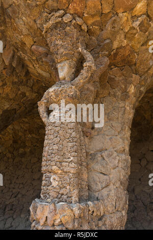 Donna permanente di sculture nel parco Guell progettato da Antoni Gaudi, Barcellona, Spagna Foto Stock