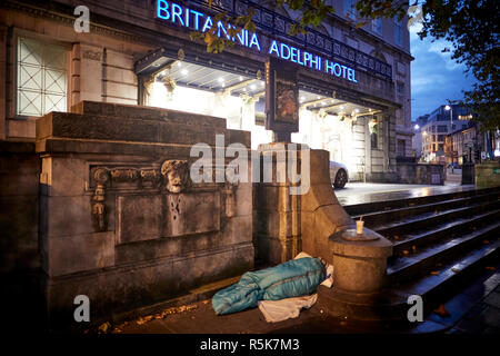 Il centro di Liverpool un senzatetto dormire in un sonno torna sul marciapiede esterno iconico Britannia Adelphi Hotel passi Foto Stock