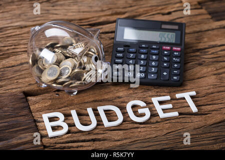 Piggybank e calcolatrice da Budget del testo in tabella Foto Stock