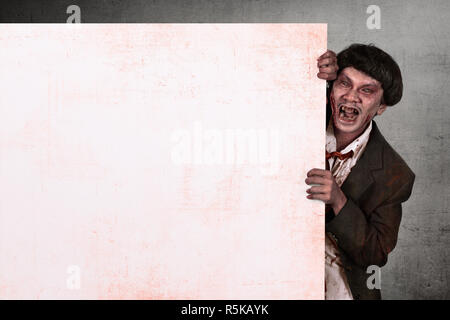 Ritratto di zombie asiatici uomo azienda vuoto banner bianco Foto Stock