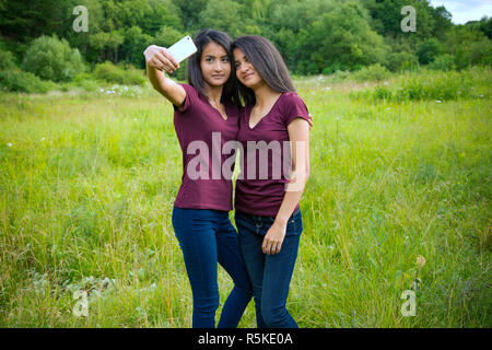 Gemelli prendere un selfie Foto Stock