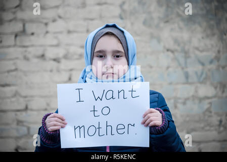 Refugee ragazza con una scritta su un foglio bianco 'voglio madre" Foto Stock