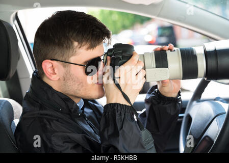 Detective privato fotografare con SLR Fotocamera Foto Stock