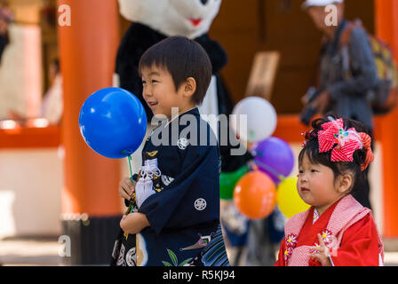 Bambini giapponesi e le famiglie che frequentano l'annuale shichi go san, o (7-5-3) cerimonia. Un tempo per vestirsi, benedetti e ricezione presenta Foto Stock