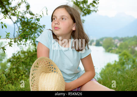 Piuttosto pre teen ragazza seduta in erba Foto Stock