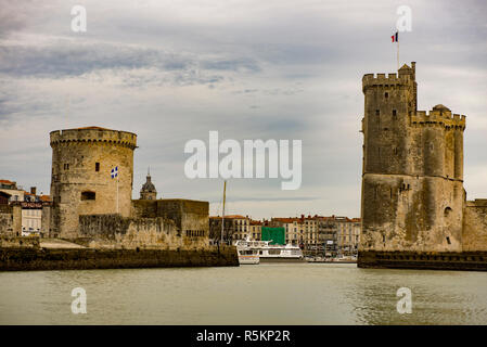 Vista panoramica dell'entrata del porto di La Rochelle, Francia con le sue torri, le case e le guglie della chiesa. Foto Stock