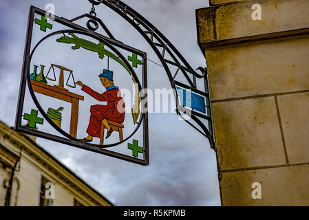 Antica farmacia sign in Francia rurale con il farmacista, scala croci verdi, snake e lizard, tutti i simboli della professione. Foto Stock