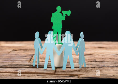 Imprenditore parlare attraverso il megafono circondato dal Team Foto Stock