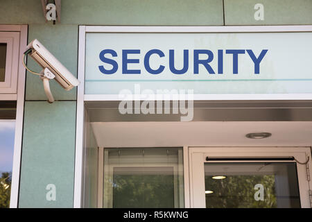 Videocamera di sicurezza e firmare all'entrata Foto Stock