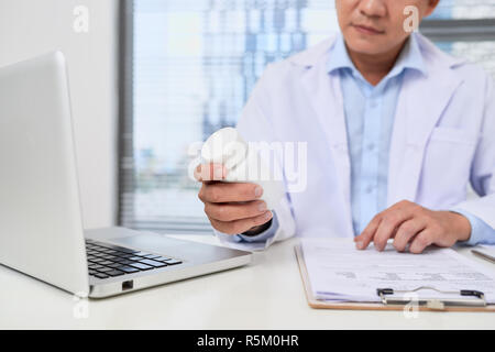 Medico compilando un modulo di storia mentre la consulenza al paziente e consiglia i metodi di trattamento e di come è possibile riabilitare. Foto Stock