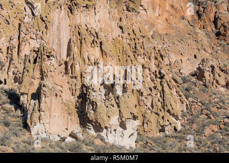Insolito, tufo colorate formazioni rocciose e le scogliere con un modello di confusione di erosione dei fori e piccole grotte in Bandelier National Monument Foto Stock