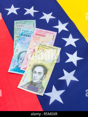 Venezuela bandiera con inutile Bolivar Fuerte ('strong') banconote - di iperinflazione nel Venezuela economia. Vedere Addit. Note Foto Stock