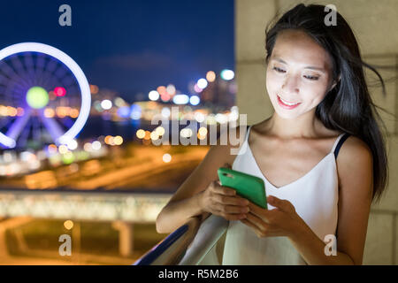 Donna texting sullo smartphone in città Foto Stock