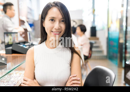 Donna che mantiene small business in negozio ottico Foto Stock