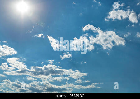 Sole brillante, heap bianche nuvole e sole brillante nel cielo blu. Foto Stock