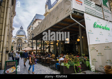 Settembre 22, 2017 Bucarest/Romania - posti a sedere esterni all' Caru cu Bere rumeno tradizionale ristorante nel centro storico downtown area; CEC Bank histor Foto Stock