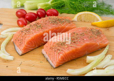 Salmone e verdure su un tagliere Foto Stock