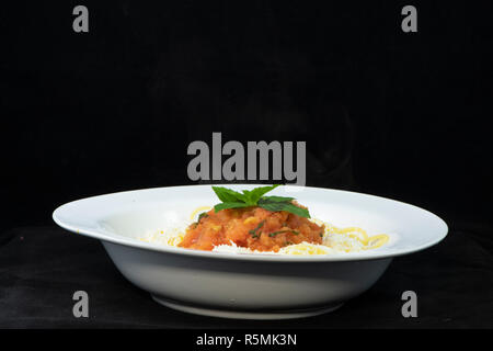 Spaghetti con pomodoro fresco e basilico e triturato halloumi sulla parte superiore Foto Stock