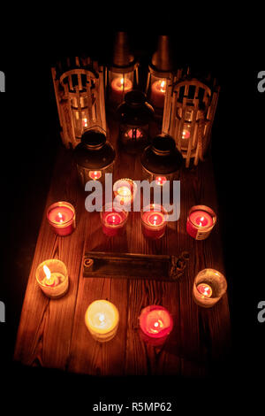 Mix di candele, lanterne e incenso su tavola in legno rustico Foto Stock