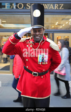 Un portiere vestito come un soldato giocattolo si erge al di fuori recentemente riaperto la FAO Schwarz flagship store al Rockefeller Plaza nel centro di Manhattan Foto Stock