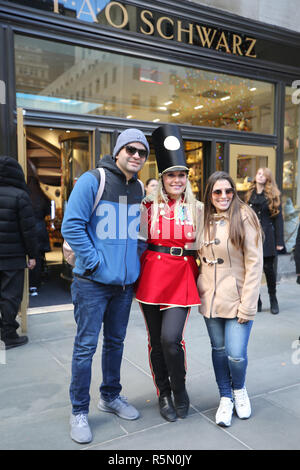 Un portiere vestito come un soldato giocattolo si erge al di fuori recentemente riaperto la FAO Schwarz flagship store al Rockefeller Plaza nel centro di Manhattan Foto Stock