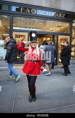 Un portiere vestito come un soldato giocattolo si erge al di fuori recentemente riaperto la FAO Schwarz flagship store al Rockefeller Plaza nel centro di Manhattan Foto Stock