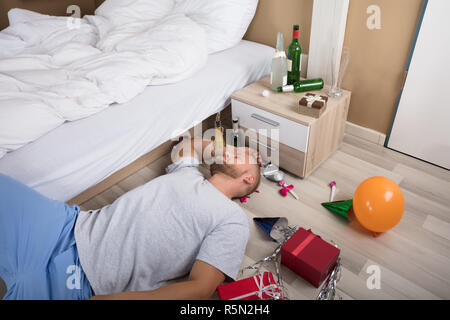 Uomo di dormire sul pavimento di legno duro Foto Stock