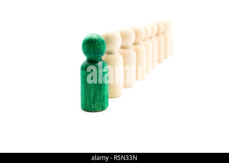 Green figura in piedi fuori dalla folla davanti alla linea di figure in legno, isolato su sfondo bianco. Il concetto di Leadership Foto Stock