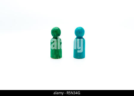 Il blu e il verde figure in legno isolato su sfondo bianco. Immagine concettuale di leadership ed essendo differente Foto Stock