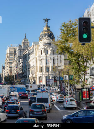 Madrid, Spagna - 29 Novembre 2018: l'ora di punta sulla Calle de Acala nella parte anteriore della metropoli di edificio, con le automobili, autobus, pedoni e motorini. Foto Stock