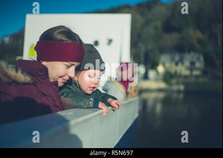 Una giovane donna e un bambino sono su un traghetto Foto Stock