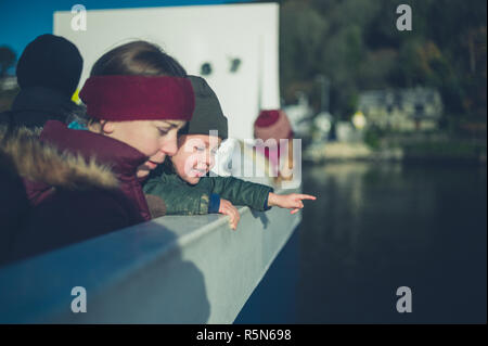 Una giovane donna e un bambino sono su un traghetto Foto Stock