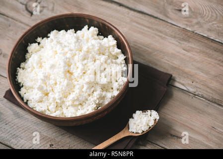 Agricoltura biologica Cottage cheese nel recipiente rustico, vicino. In casa cottage cheese per mangiare sano la dieta alimentare. Foto Stock