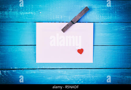 Foglio di carta bianco con un clothespin in legno Foto Stock