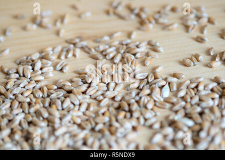 Sparse in grani di grano su sfondo di legno vicino fino Foto Stock