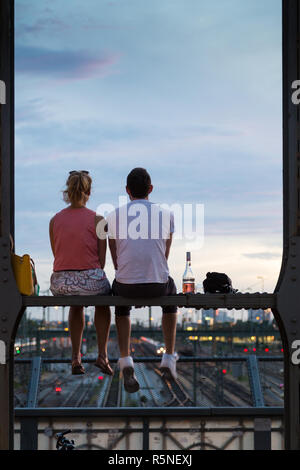 Coppia giovane sulla data romantico sulla ferrovia urbana bridge, Monaco di Baviera, Germania. Foto Stock