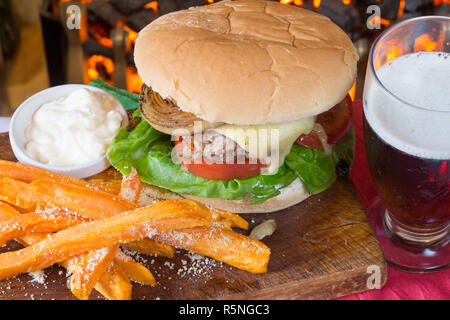 Classico pub Inglese pasto a base di formaggio hamburger con patate dolci patatine fritte e un aglio maionese Foto Stock