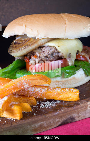 Classico pub Inglese pasto a base di formaggio hamburger con patate dolci patatine fritte e un aglio maionese Foto Stock