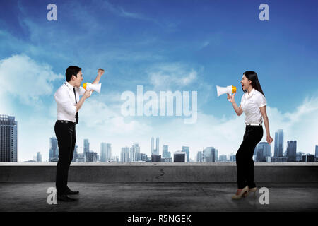 Asian business l uomo e la donna gridare ogni altro Foto Stock