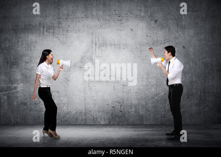 Asian business l uomo e la donna gridare ogni altro Foto Stock