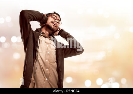 Asian giovane uomo ascoltare la musica tramite le cuffie Foto Stock