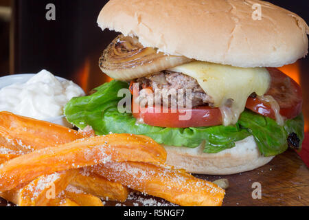 Classico pub Inglese pasto a base di formaggio hamburger con patate dolci patatine fritte e un aglio maionese Foto Stock